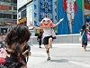 「MUNI」をかぶり街中でパフォーマンスを行う東清さん